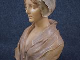 a statue of a woman with a hat on her head