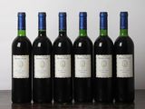 six bottles of wine are lined up on a wooden table