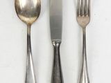 three forks, a spoon, and a knife on a table
