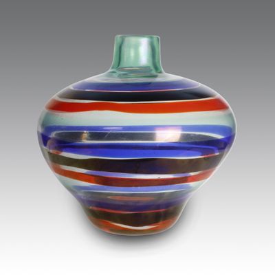 a glass vase with a multicolored striped design on it