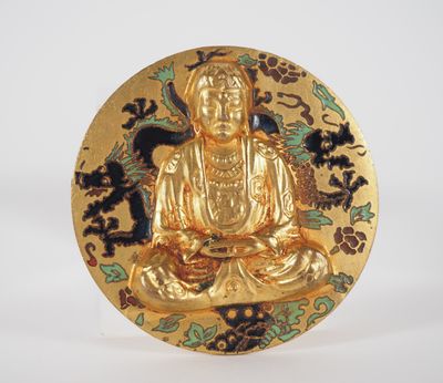 assiette dorée représentant un Bouddha doré assis sur un fond noir et blanc