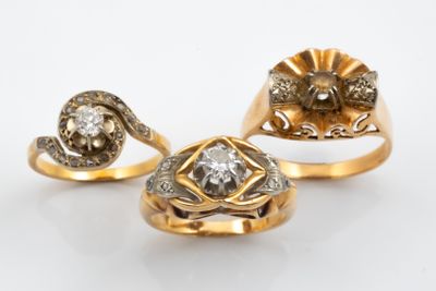 three gold rings with diamonds on a white background