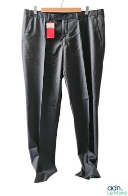 un pantalon noir avec une étiquette rouge accroché à un cintre
