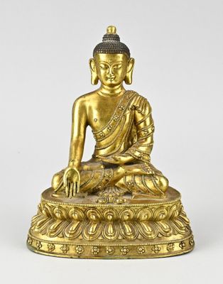 une statue en or représentant une personne assise en position du lotus