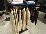 a rack of shirts and jackets on display in a clothing store