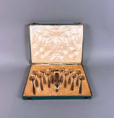 six cuillères dans un étui posé sur une table