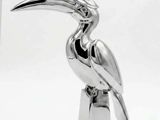 a silver bird that is sitting on top of a stand