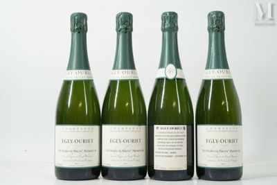 quatre bouteilles de champagne sont alignées sur une surface blanche
