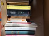 a cardboard box filled with many books on top of it