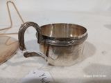 une coupe en argent posée sur une table, avec une étiquette de prix dessus