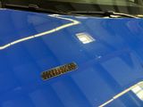 a close up of a blue car with a sticker on it