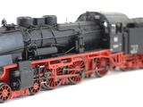 a black and red model train on a white background