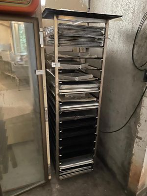 une photo d'une pièce avec un réfrigérateur et une étagère remplie de casseroles