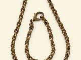 a close up of a necklace and a chain on a white background