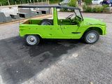 a green jeep parked in a parking lot next to a building