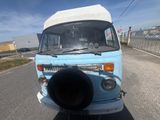 une petite camionnette bleue garée sur le bord de la route