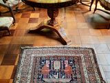 a rug on the floor in a room with chairs and a table