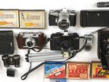 beaucoup de vieux appareils photo et d'autres objets posés sur la table