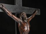 a statue of jesus on a cross with a black background