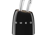 black and white image of a black toaster with two knives in it