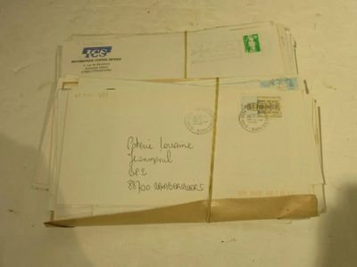 une pile de lettres et d'enveloppes posée sur une table