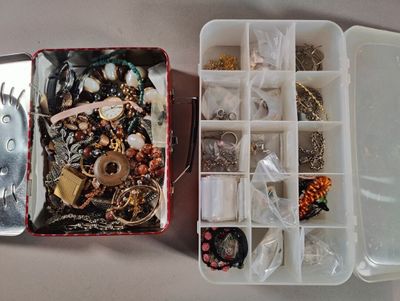 two boxes of jewelry sitting on a table next to each other