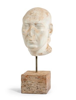 une image représentant une sculpture représentant une tête d'homme posée sur un bloc de bois