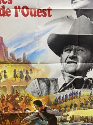 movie poster of a man riding a horse in front of a crowd of people