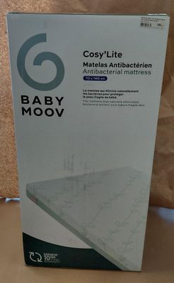 Le carton contenant le matelas Babymoov est posé sur la table.