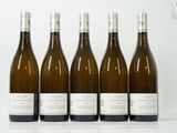 six bouteilles de vin sont alignées sur une surface blanche