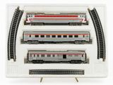 three model trains in a display case on a white surface