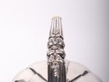 a silver plate with a spoon on it on a table