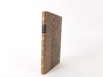 an old book sitting on top of a white table next to a white wall