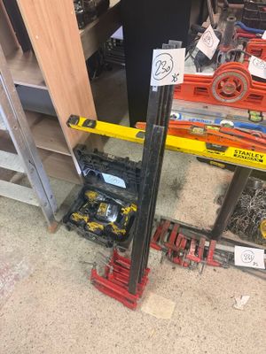 un tas d'outils par terre, à côté d'une étagère