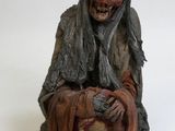 une figurine représentant un vieil homme assis par terre