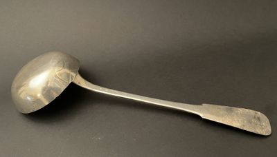 an old spoon with a metal handle sitting on a black surface