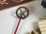 a picture of a small metal object with a red handle