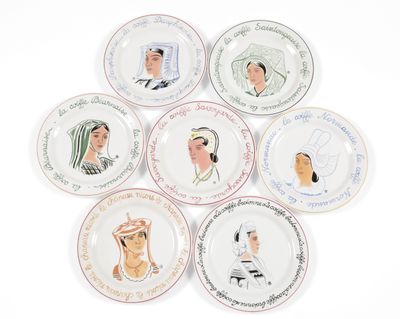 several plates with different designs of people on them on a white surface