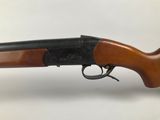 a rifle with a wooden barrel and a black handle