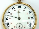 a gold pocket watch with roman numerals on the face