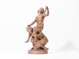 statue en bronze représentant une femme assise sur un rocher avec un chien