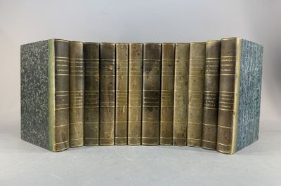 six vieux livres sont alignés sur une surface blanche