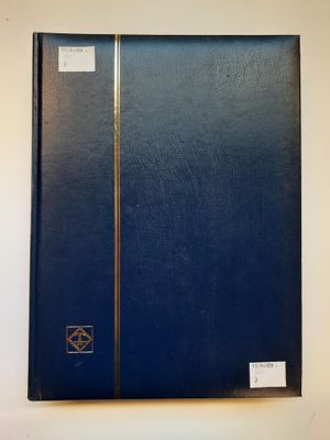 un livre bleu à la couverture noire posé sur une table