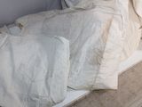 a bed with a white comforter and pillows on top of it