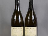 two bottles of wine sitting on top of a table next to each other