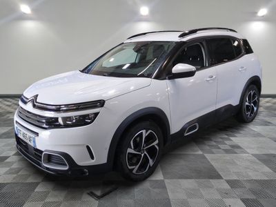 a white citrole is parked in a room with a checkered floor