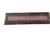 un tapis marron et noir orné d'un motif en losanges