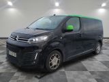 une camionnette noire aux finitions vertes garée sur un sol à damier