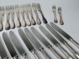 a lot of silverware on a table with forks and knives