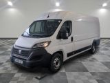 la camionnette blanche est garée dans une grande pièce au sol en damier